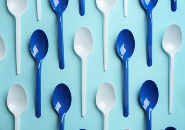 Photo of Flat lay composition with plastic spoons on color background. Table setting