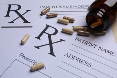Photo of Medical prescription forms, pills and bottle on beige background, closeup