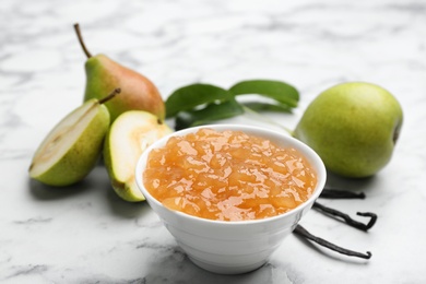 Photo of Delicious pear jam and fresh fruits on white marble table