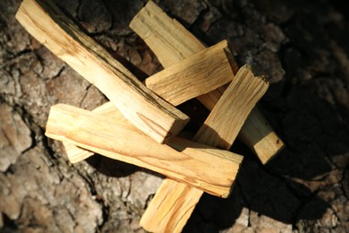 Palo santo sticks on tree bark, top view