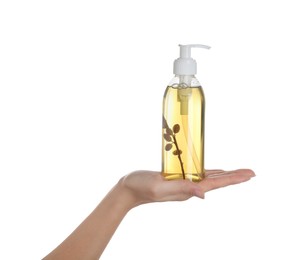Photo of Woman holding liquid soap dispenser with twig on white background, closeup