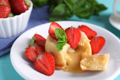 Photo of Tasty vanilla fondant with white chocolate and strawberries on table, closeup