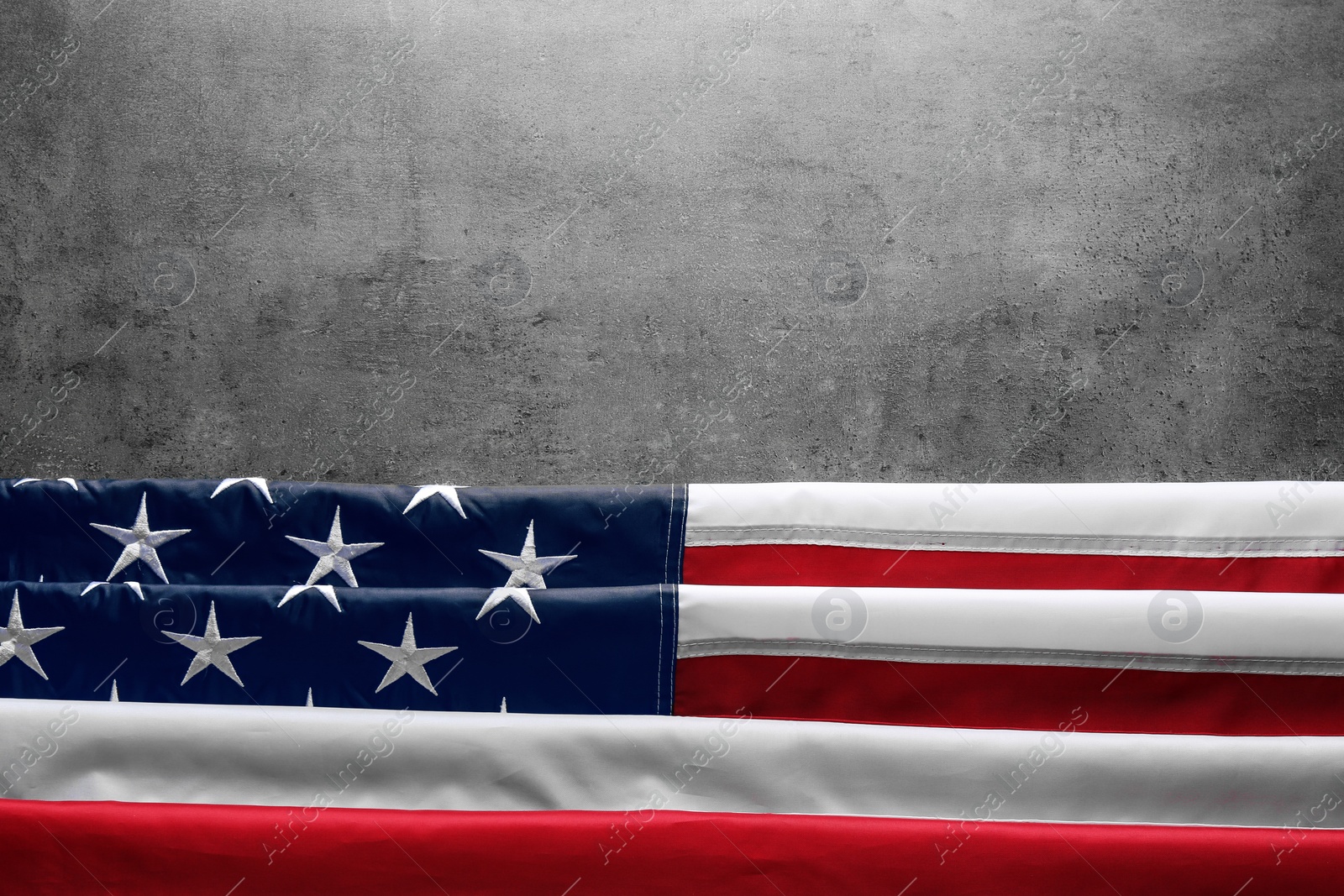 Photo of American flag on grey background, top view with space for text