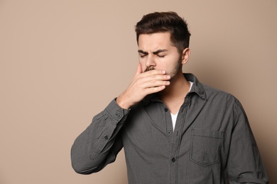 Handsome young man coughing against color background. Space for text