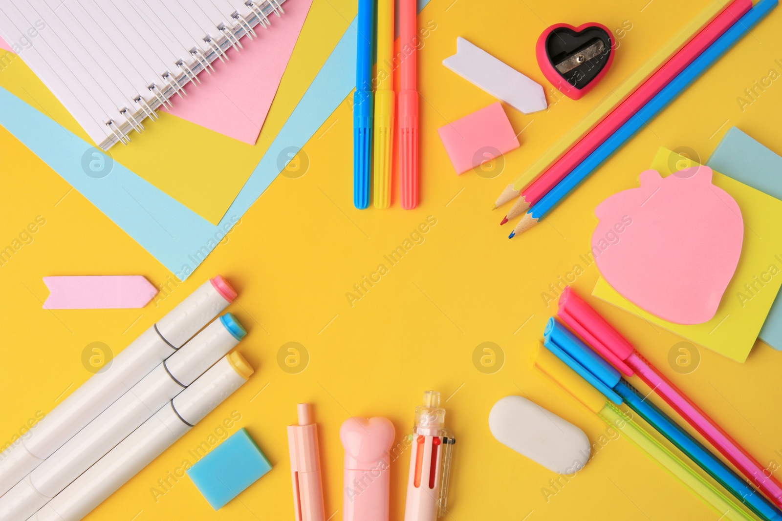 Photo of Frame of different school stationery on yellow background, flat lay with space for text. Back to school