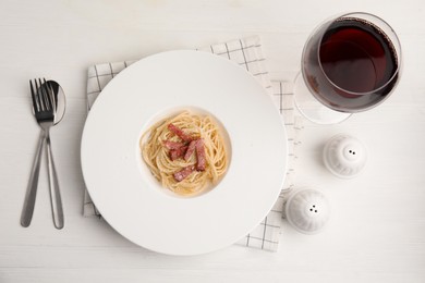 Photo of Delicious Carbonara pasta served on white wooden table, flat lay