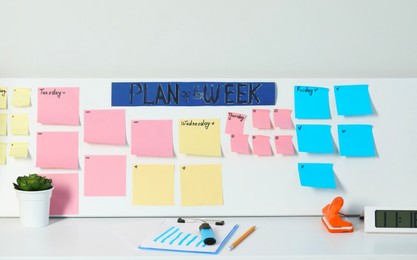 Photo of Business process planning and optimization. Workplace with colorful paper notes and other stationery on white table