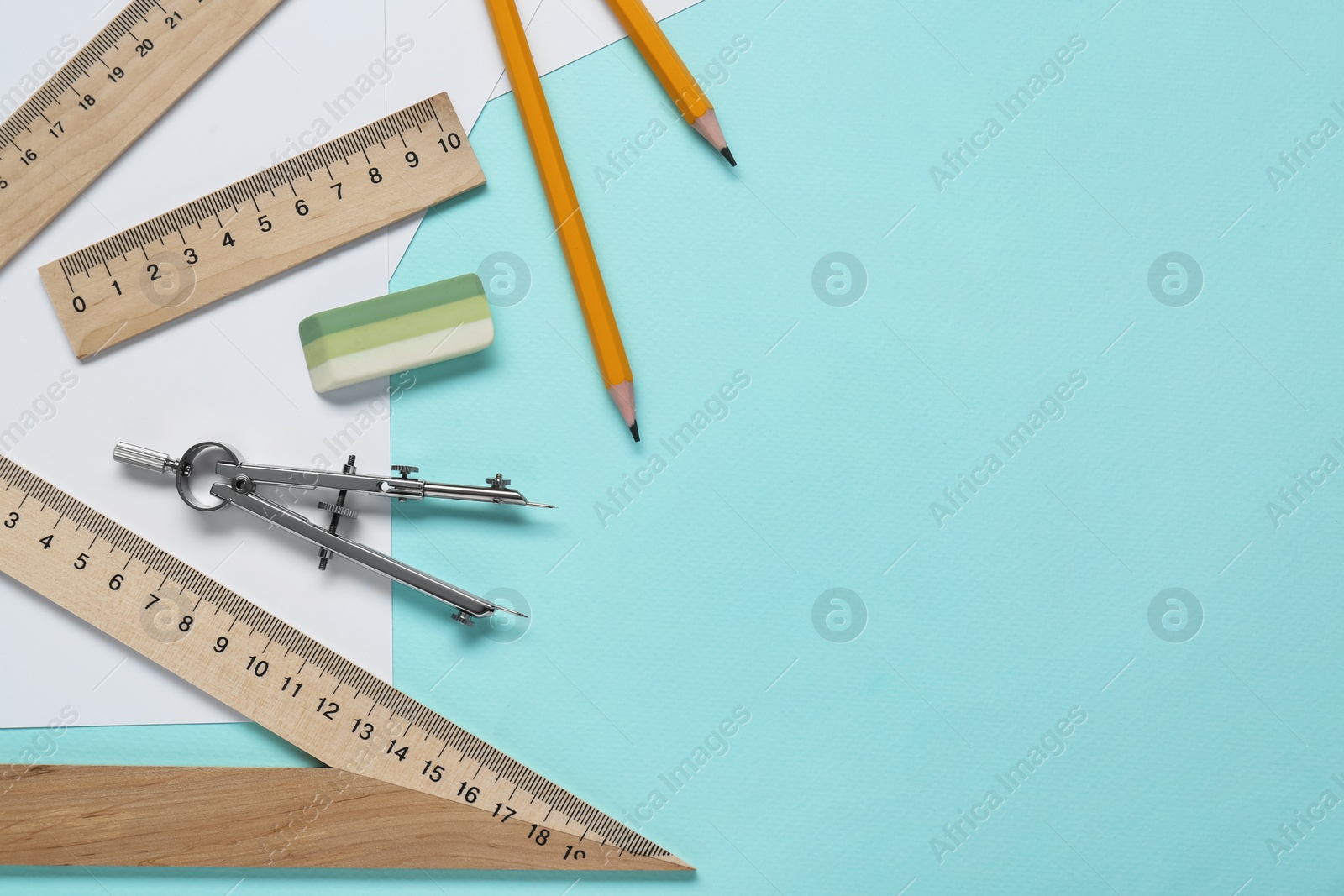 Photo of Different rulers and compass on turquoise background. Space for text