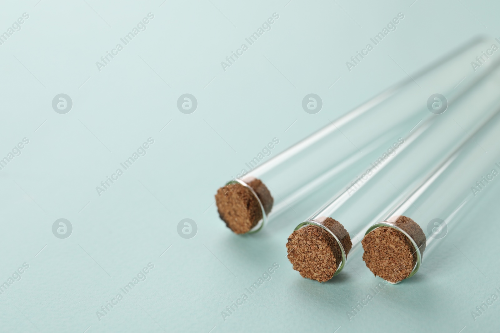 Photo of Test tubes on turquoise background, closeup and space for text. Laboratory glassware