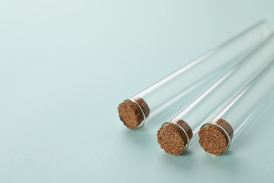 Test tubes on turquoise background, closeup and space for text. Laboratory glassware