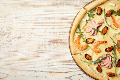 Delicious seafood pizza on white wooden table, top view. Space for text