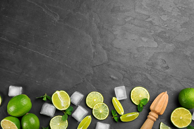 Photo of Lemonade layout with juicy lime slices, mint and ice cubes on black table, top view. Space for text. Space for text