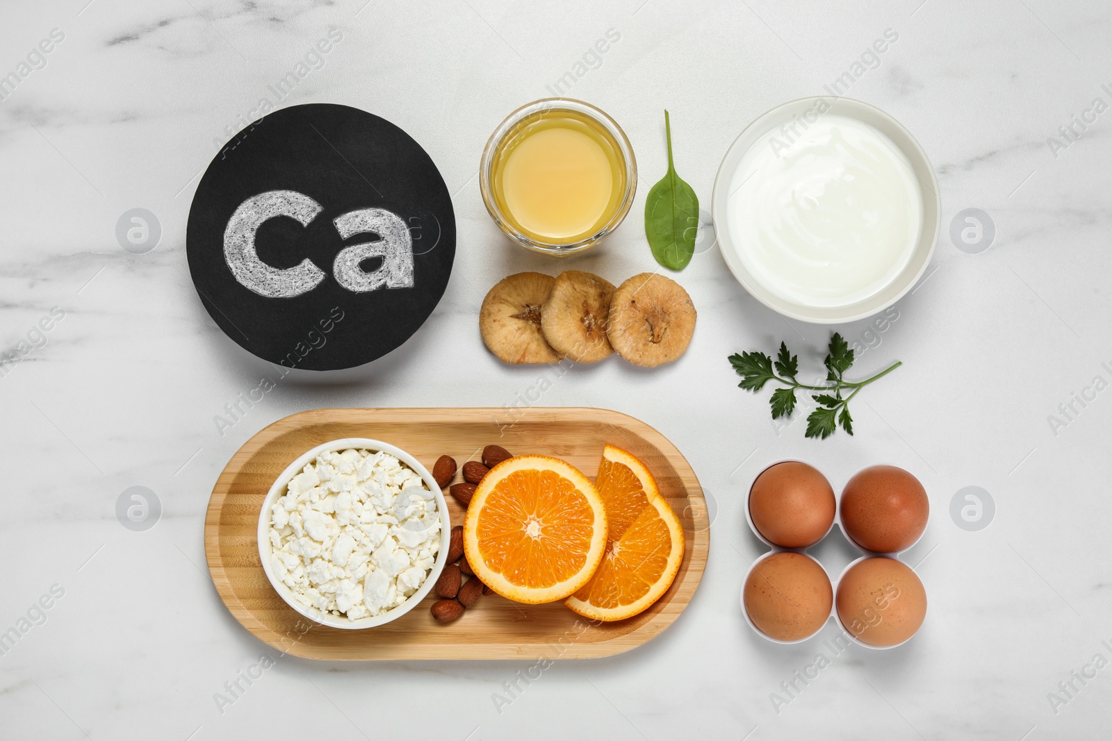 Photo of Set of natural food high in calcium on white marble table, flat lay