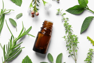 Photo of Bottle of essential oil and different herbs on white background, flat lay