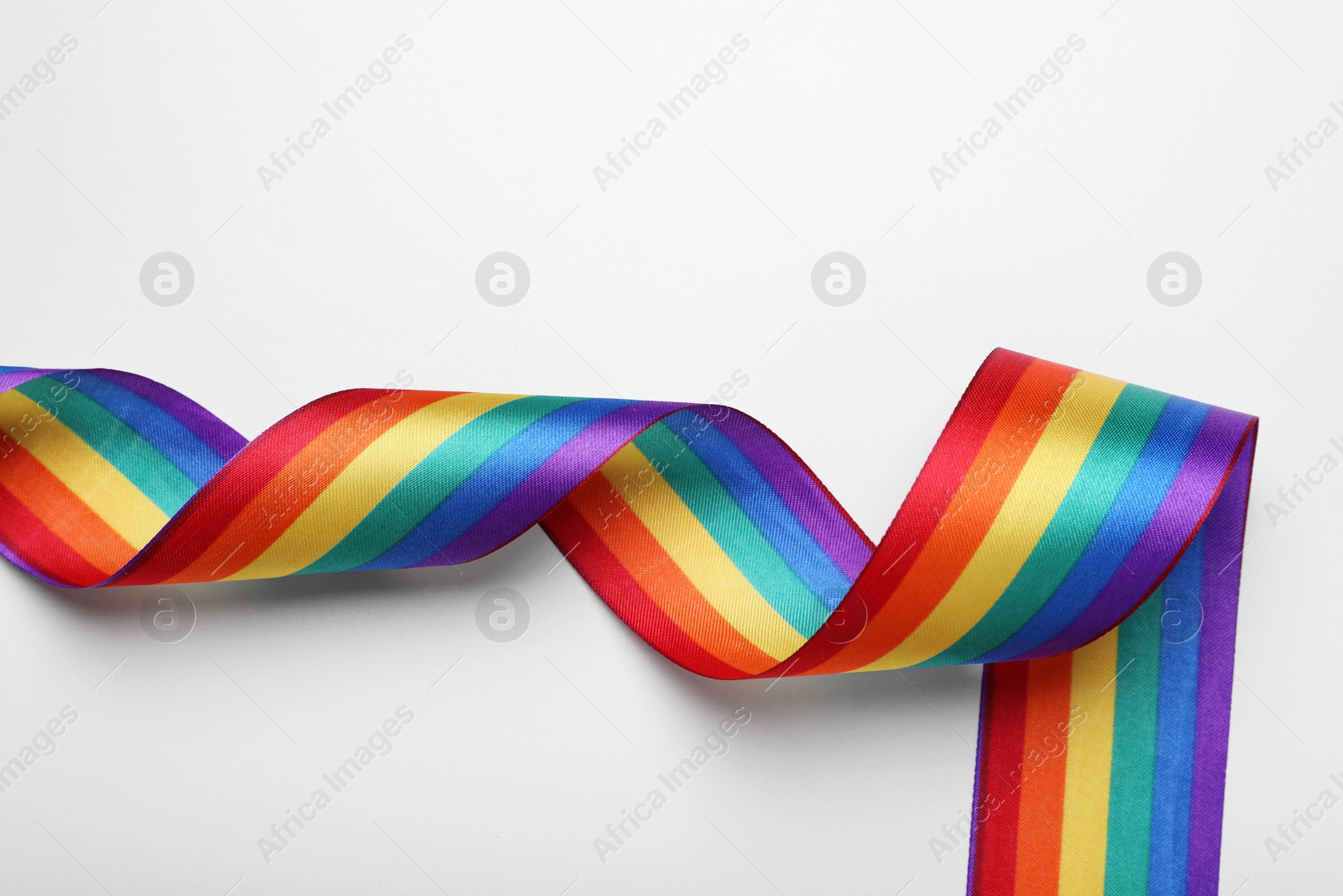 Photo of Rainbow ribbon on white background, top view. LGBT pride