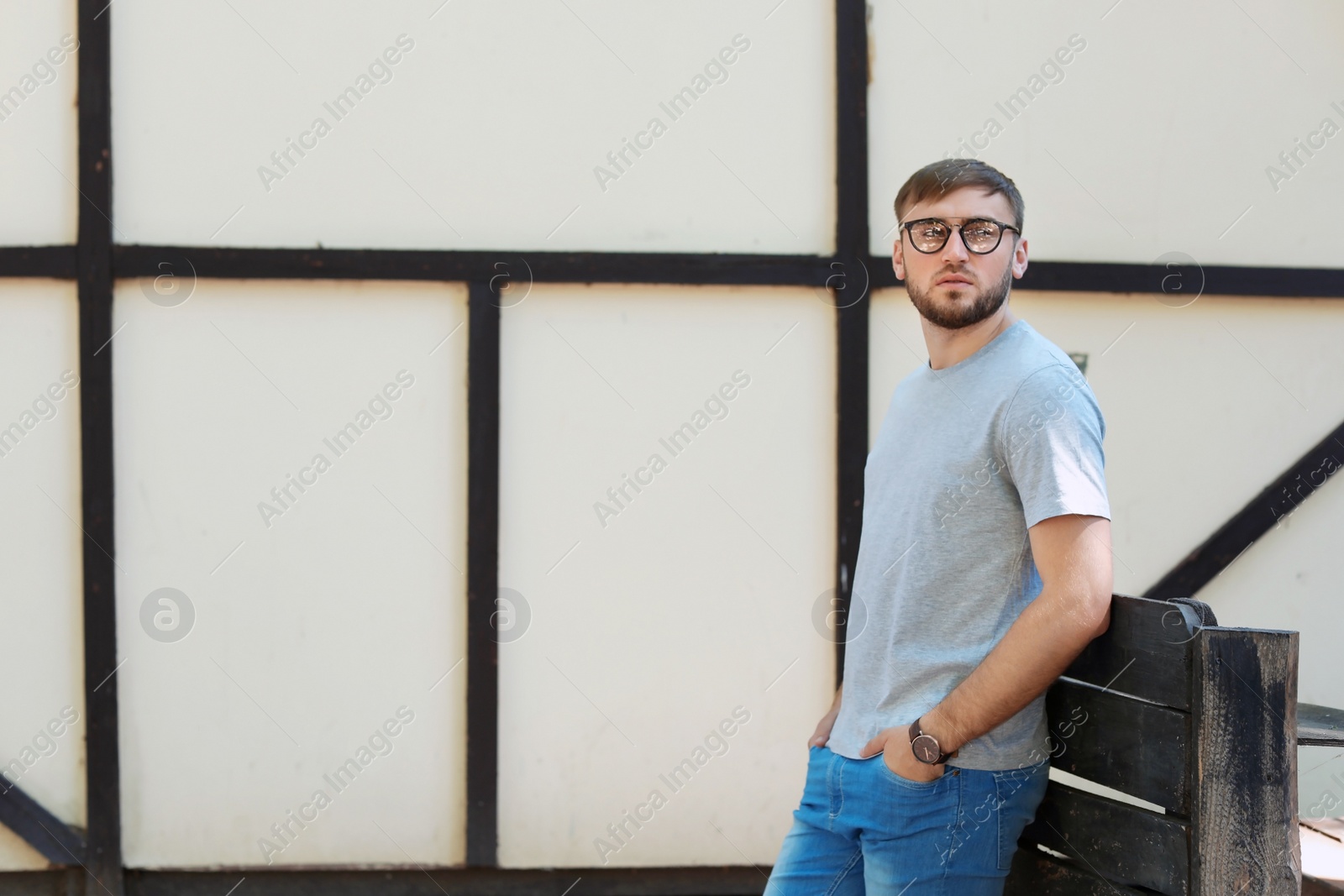 Photo of Young man wearing gray t-shirt on street. Urban style