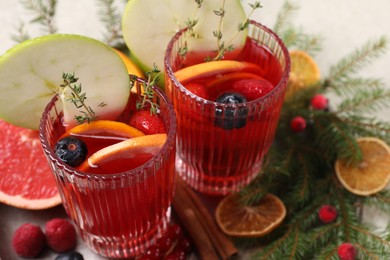 Aromatic Christmas Sangria in glasses served on table, closeup