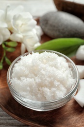 Glass bowl with natural coconut scrub on wooden tray