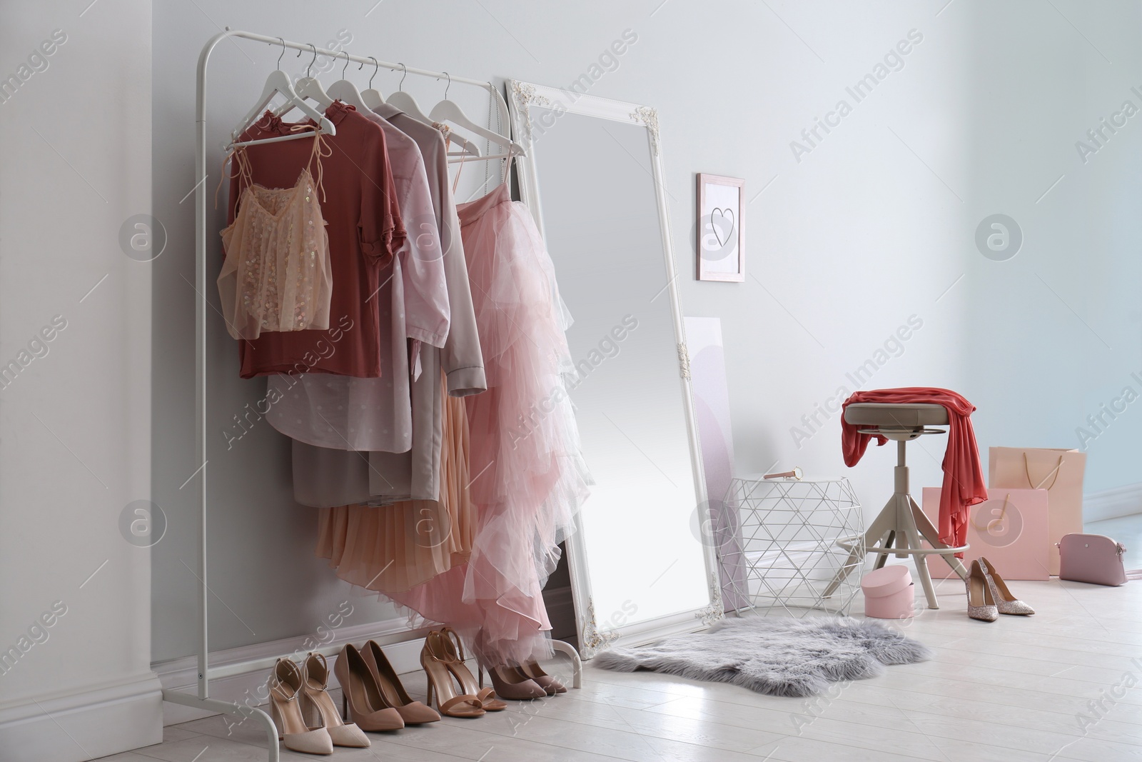 Photo of Modern dressing room interior with clothing rack and mirror