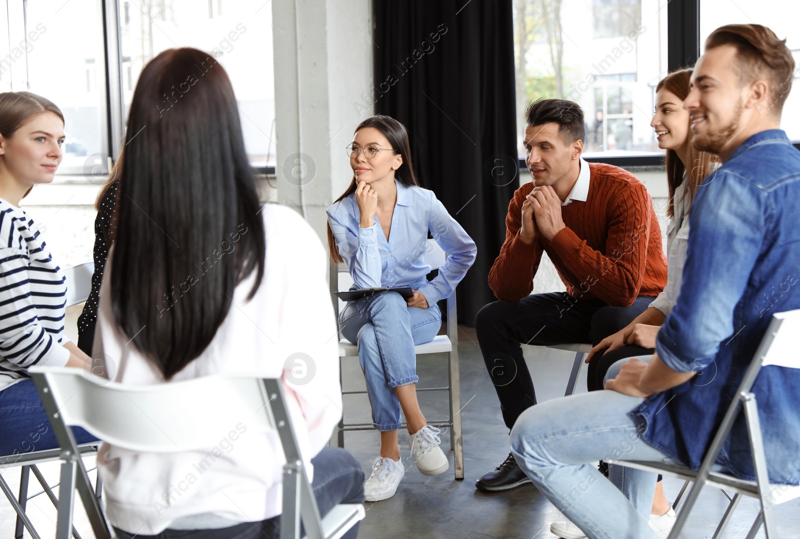 Photo of Psychotherapist working with patients in group therapy session indoors