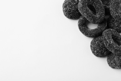 Photo of Tasty liquorice candies on light background, top view. Space for text