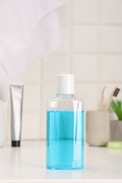 Photo of Bottle of mouthwash on white table in bathroom