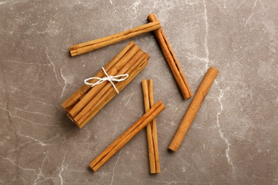 Photo of Aromatic cinnamon sticks on grey table, flat lay