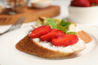 Photo of Delicious ricotta bruschettas with strawberry and mint on plate, closeup