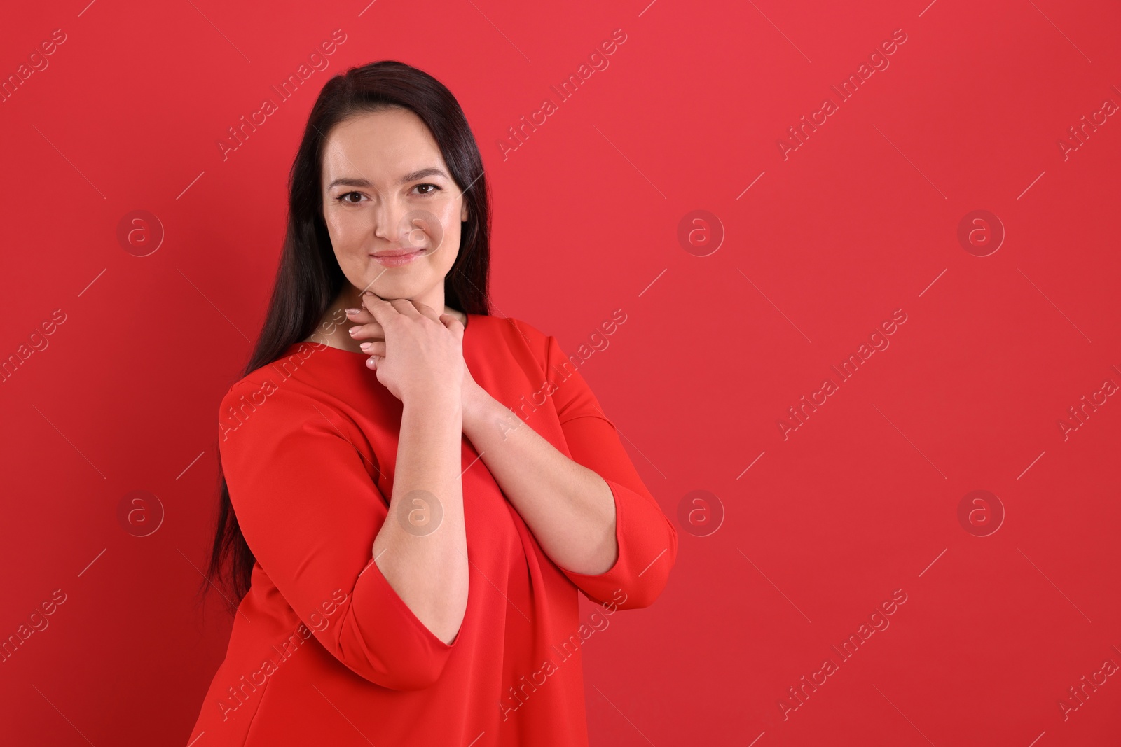 Photo of Beautiful overweight woman in dress on red background. Space for text