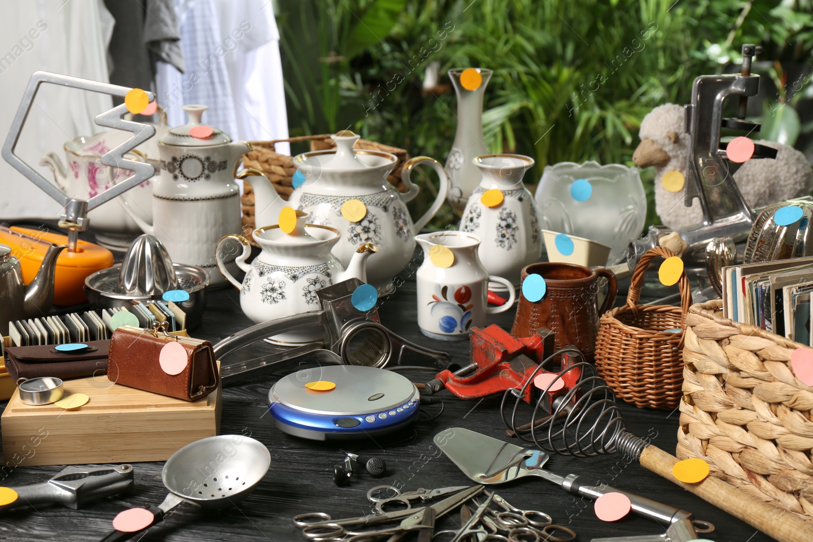 Photo of Many different stuff on black wooden table. Garage sale