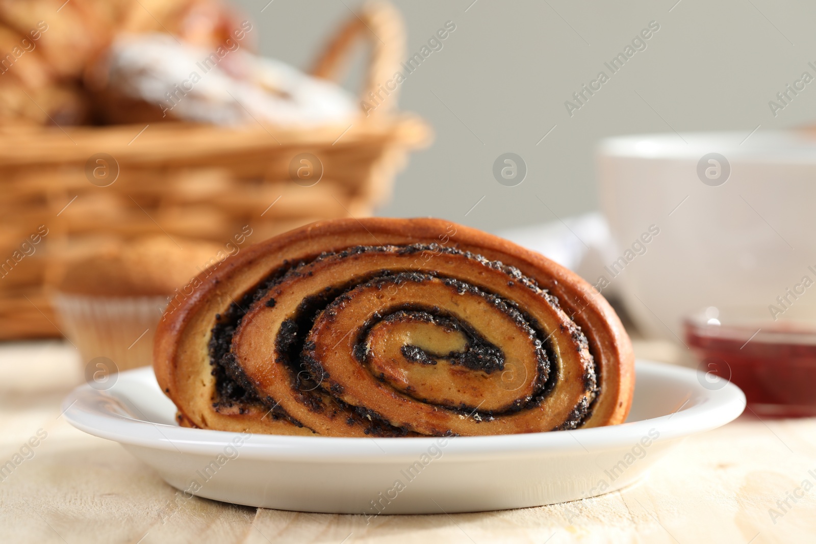 Photo of Tasty bun with poppy seeds on table, closeup