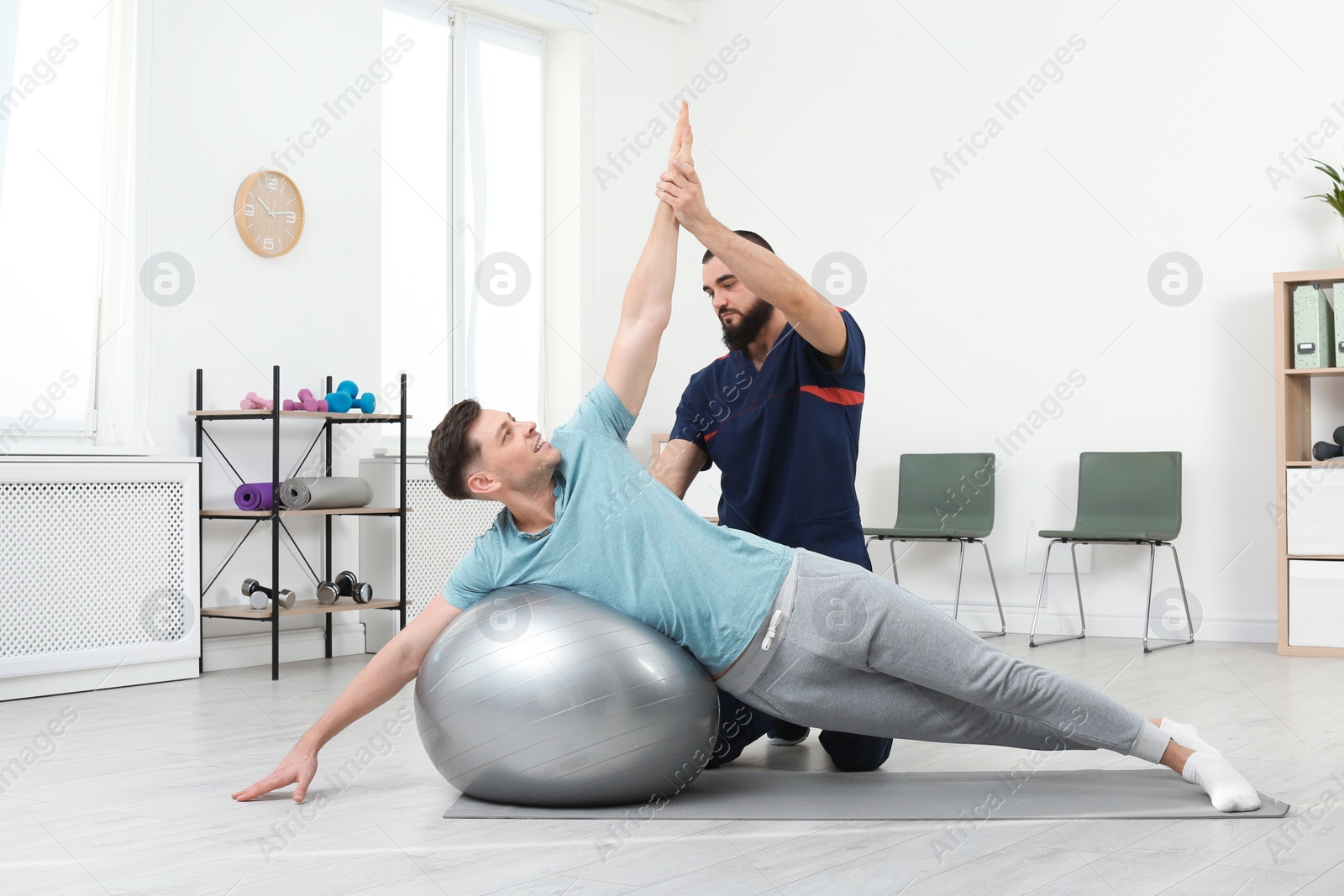 Photo of Physiotherapist working with patient in clinic. Rehabilitation therapy