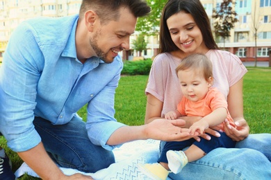 Photo of Happy family with adorable little baby outdoors