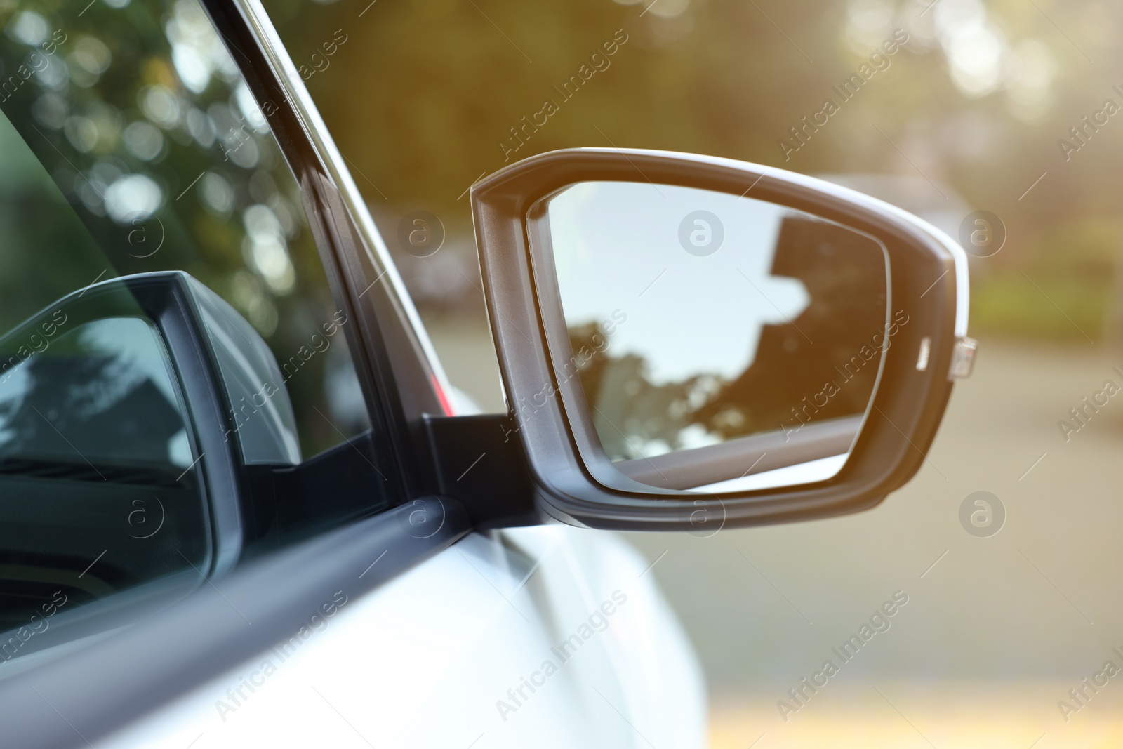 Photo of Side view mirror of modern car on blurred background, closeup