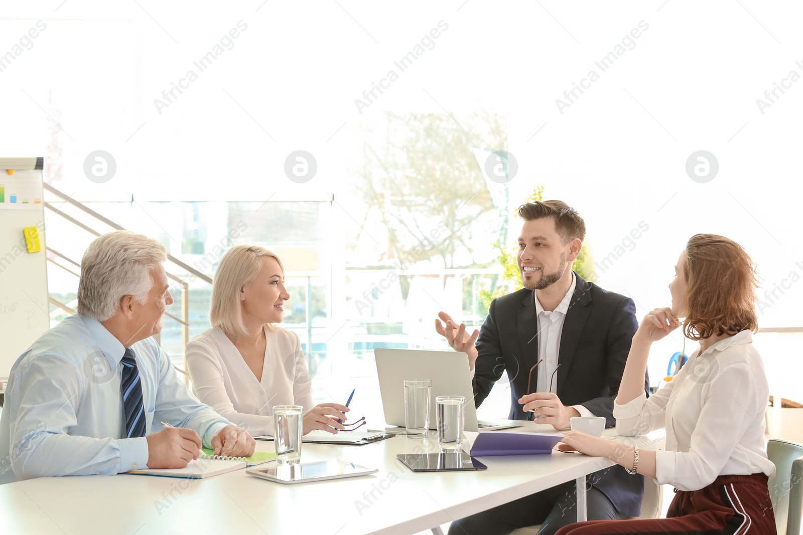 Photo of Group of people discussing ideas at table in office. Consulting service concept