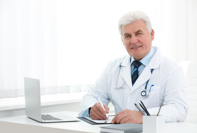 Photo of Portrait of senior doctor in white coat at workplace