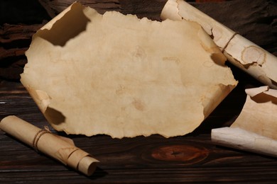 Photo of Sheets of old parchment paper on wooden table