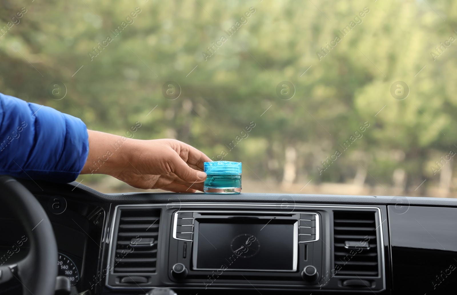 Photo of Man putting air freshener on dashboard in car, closeup. Space for text