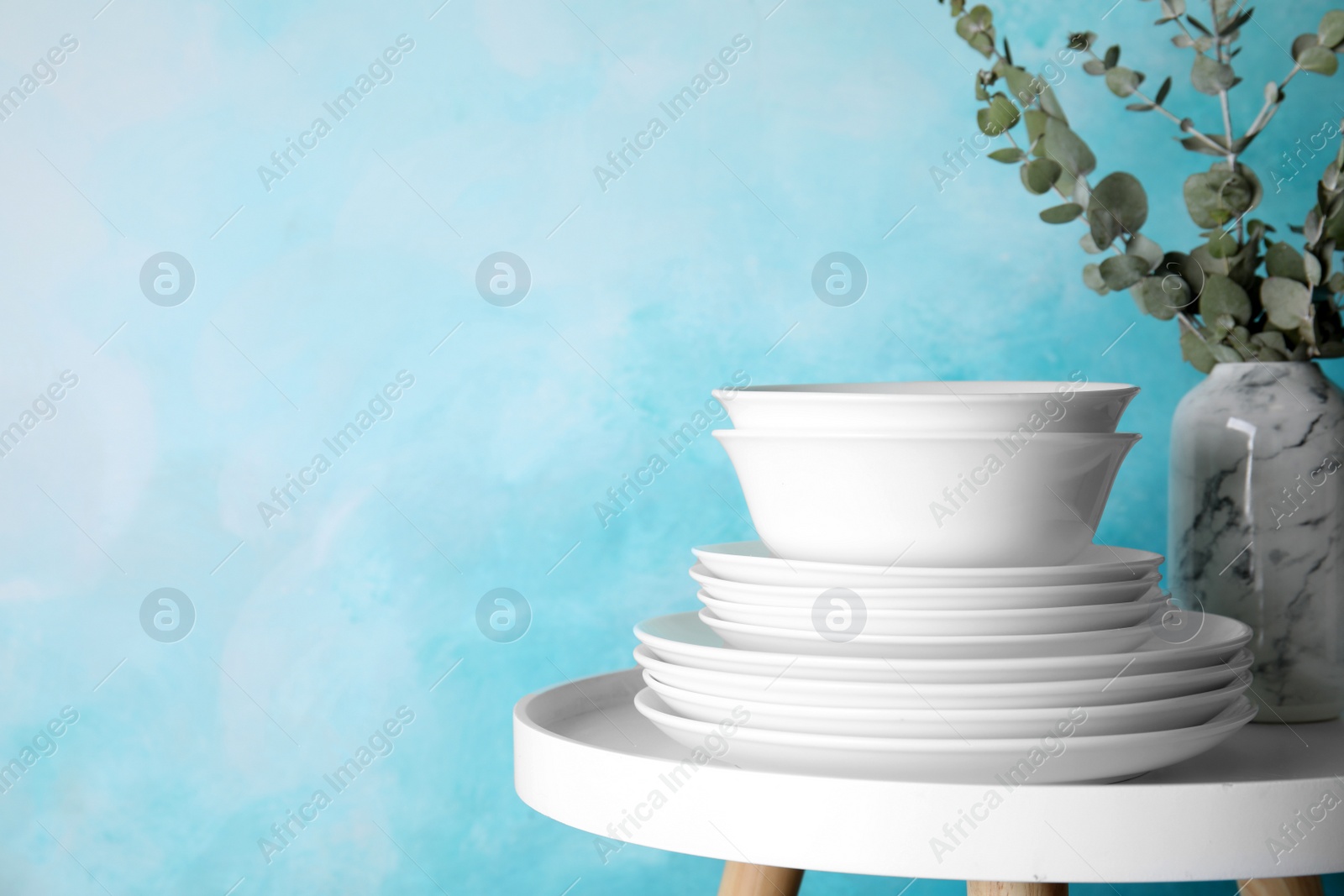 Photo of Composition with dinnerware on table against color background, space for text. Interior element