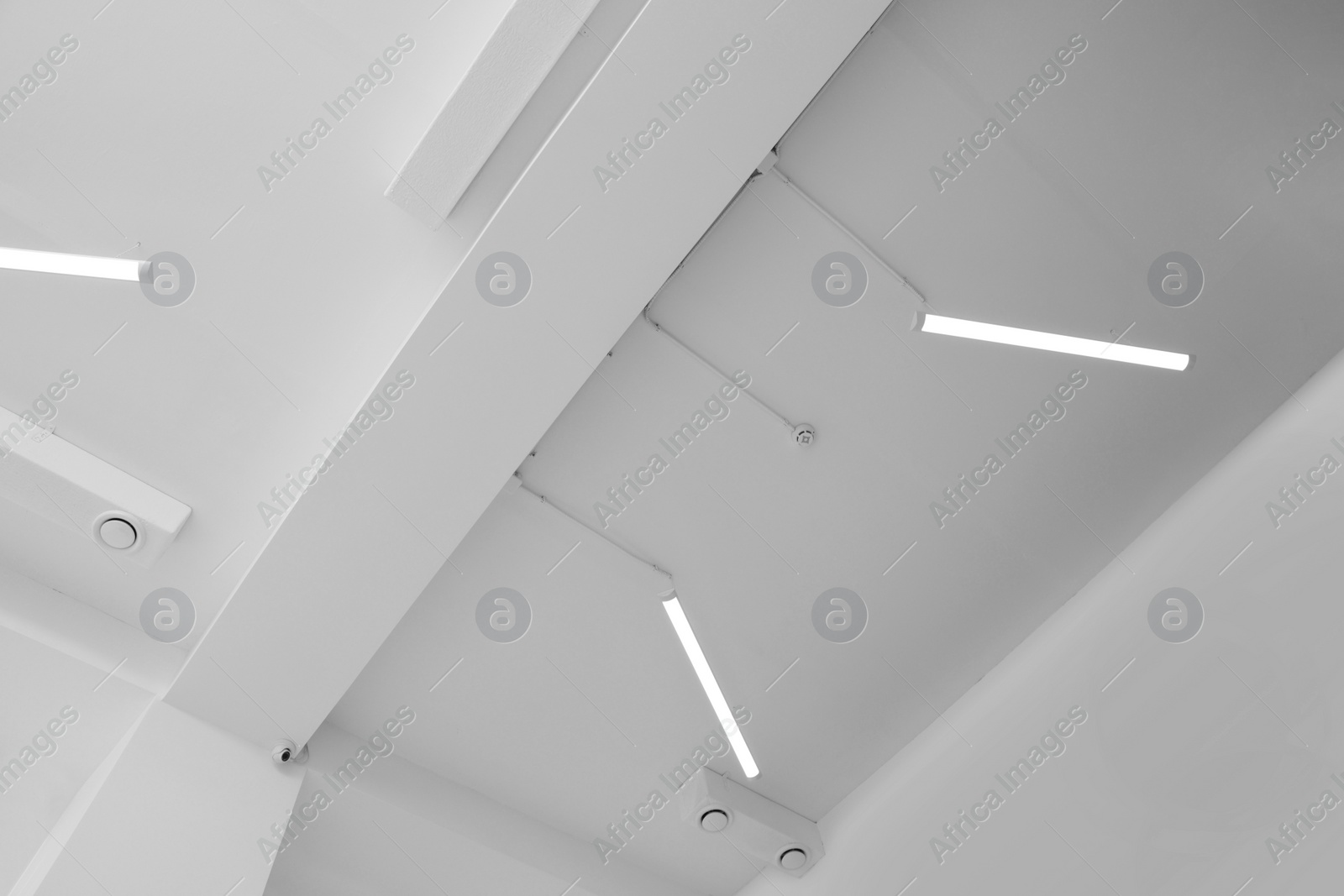 Photo of Ceiling with modern lights in room, low angle view