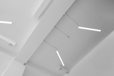 Photo of Ceiling with modern lights in room, low angle view