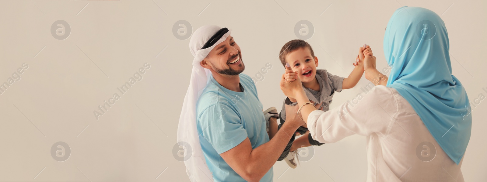 Image of Happy Muslim family spending time together on beige background, space for text. Banner design 