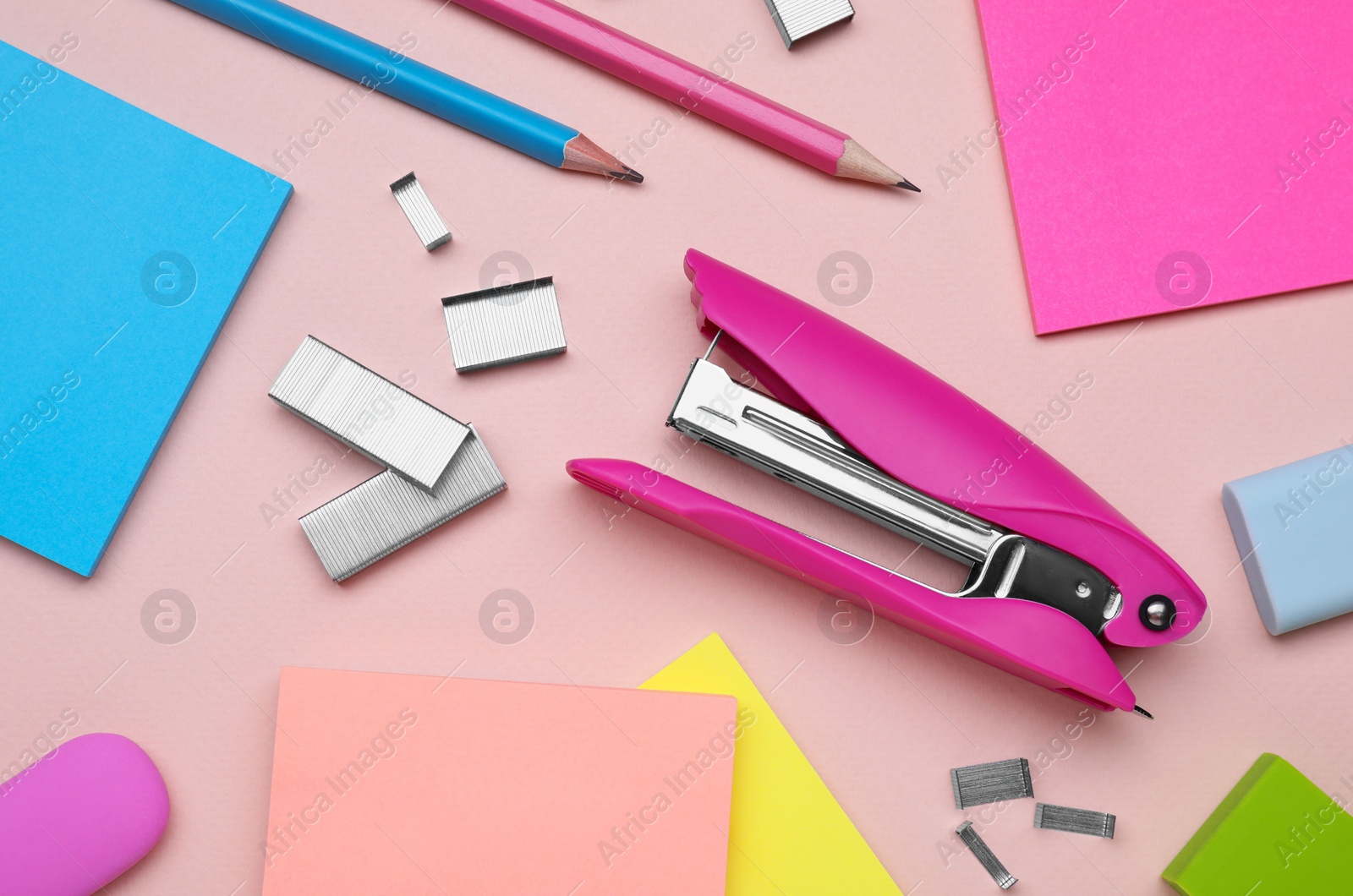 Photo of Flat lay composition with new stapler on pink background