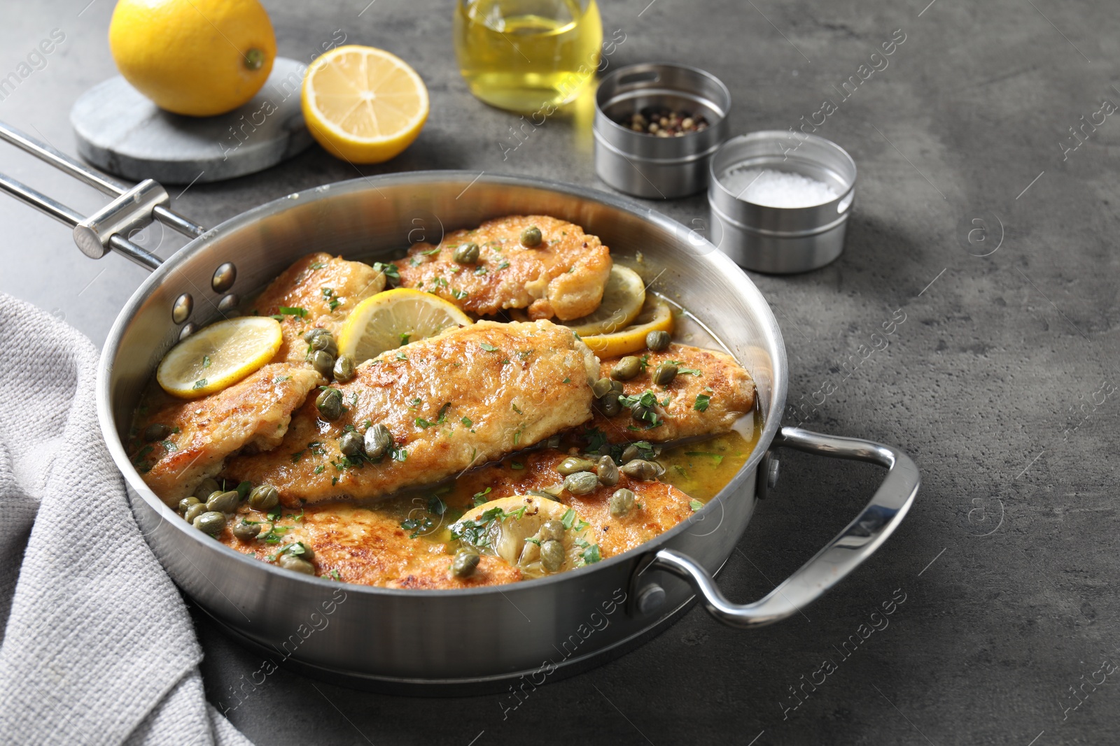 Photo of Delicious chicken piccata in pot on grey table