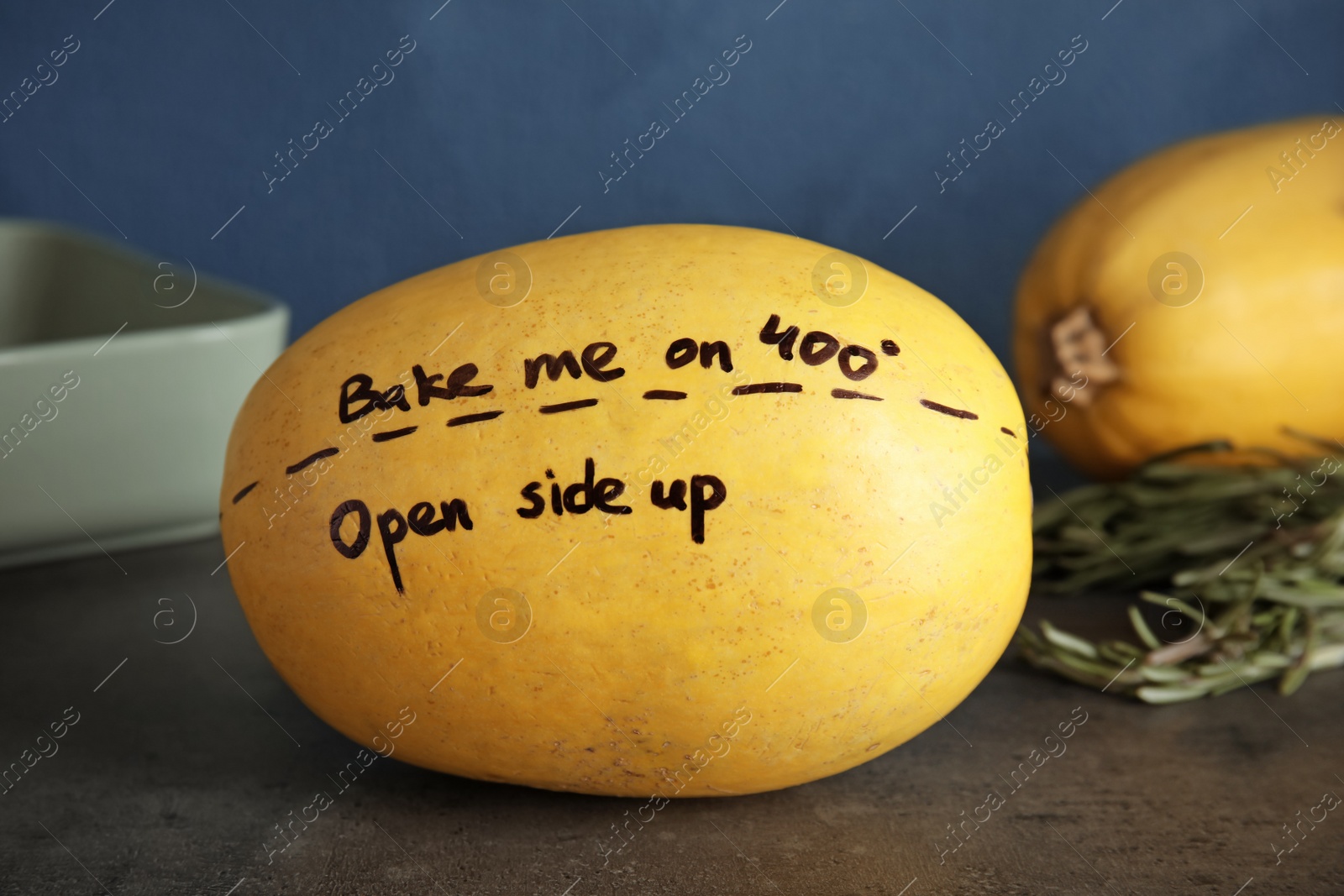 Photo of Ripe spaghetti squash with cooking instructions on gray table