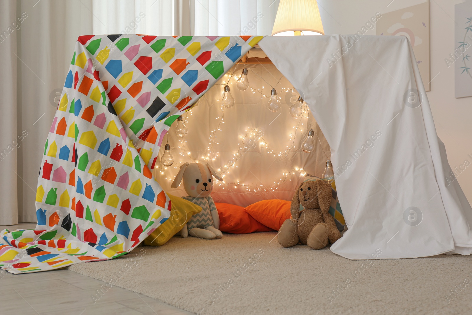 Photo of Play tent decorated with festive lights in modern child's room