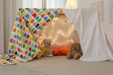 Photo of Play tent decorated with festive lights in modern child's room