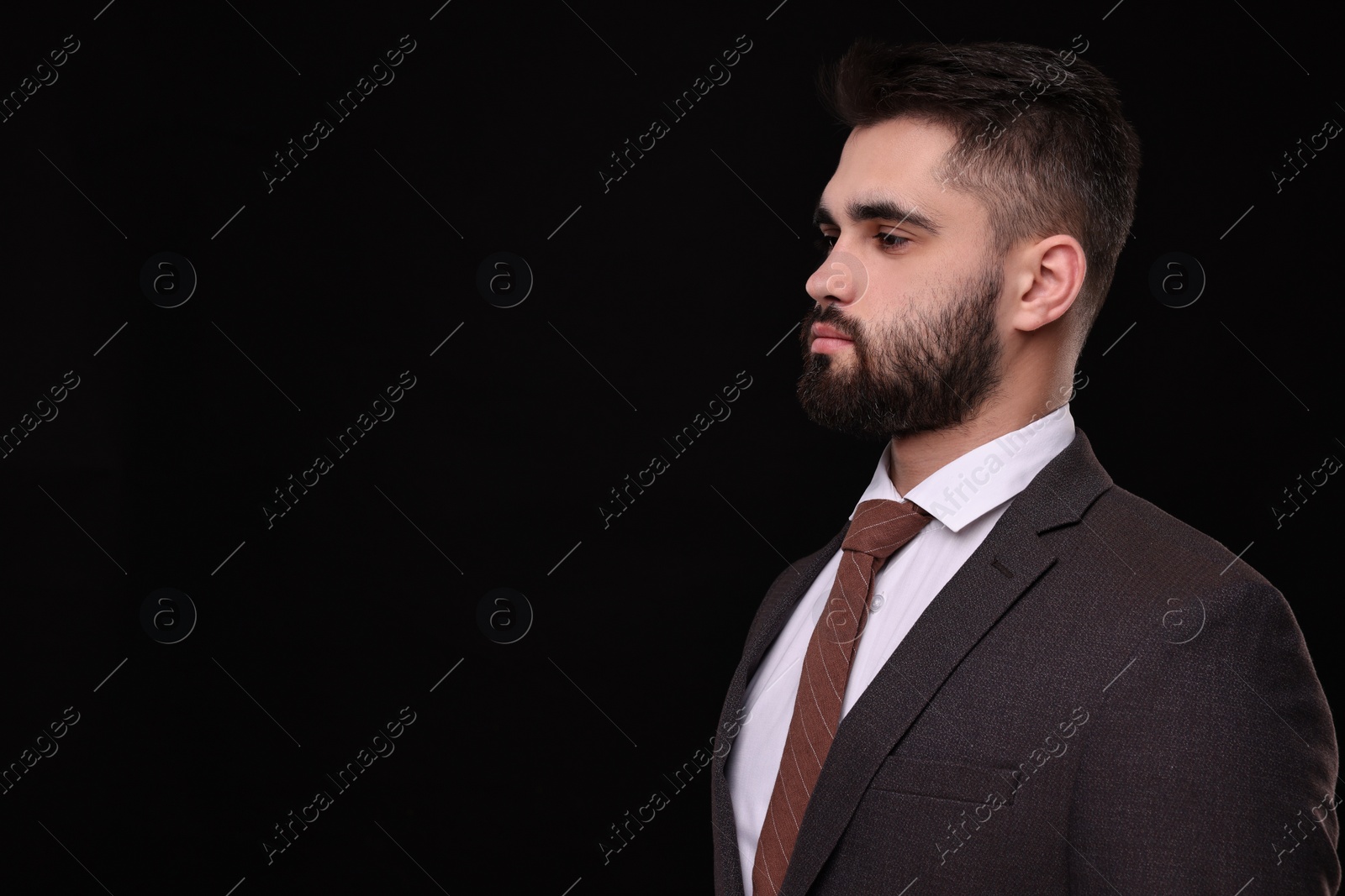 Photo of Handsome businessman in suit and necktie on black background. Space for text