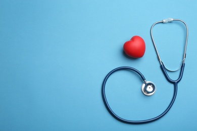 Photo of Stethoscope, red heart and space for text on blue background, flat lay. Health insurance concept