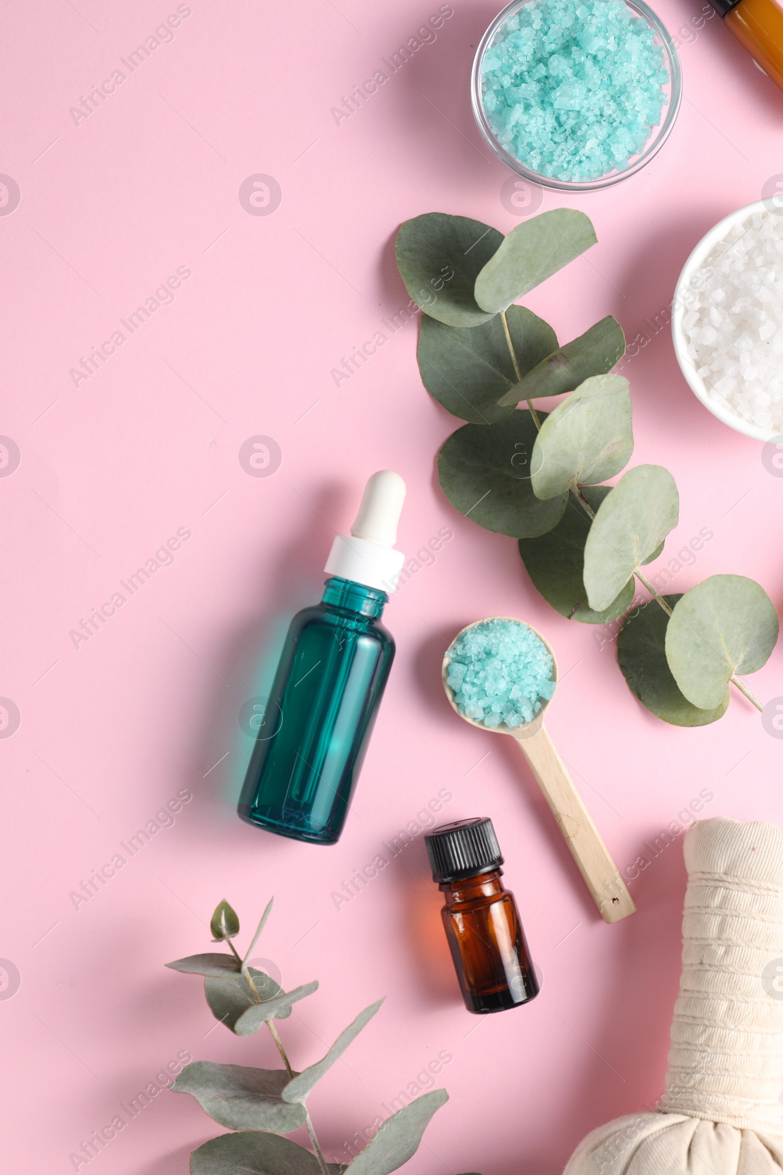 Photo of Different aromatherapy products and eucalyptus branches on pink background, flat lay